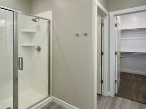 Bathroom featuring hardwood / wood-style floors and a shower with door