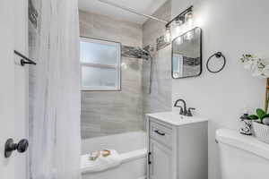 Full bathroom featuring vanity, shower / tub combo, and toilet