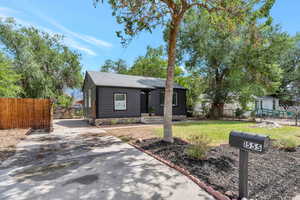 View of front facade with a front yard. Long driveway can fit RV behind the secured fence.