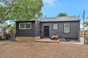 Back of house with central AC unit and deck area.