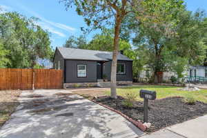 Ranch-style home with a front lawn and mature trees