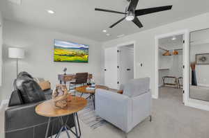 Primary Bedroom with sitting area, desk, and 65" TV