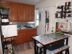 Kitchen with backsplash and light tile patterned flooring