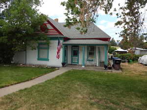 View of front facade featuring a front lawn and covered porch