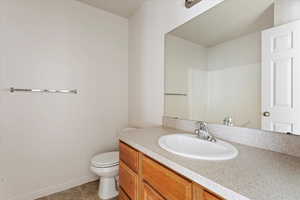 Bathroom featuring tile patterned floors, toilet, and vanity