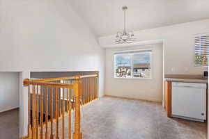 Interior space featuring a notable chandelier, vaulted ceiling, and light tile patterned floors