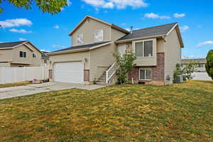 View of front of property featuring a front yard and a garage