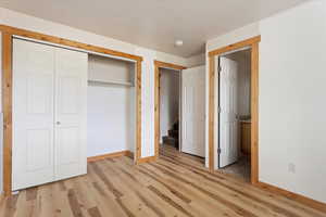 Unfurnished bedroom featuring a closet and light hardwood / wood-style floors