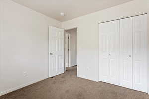 Unfurnished bedroom featuring carpet floors and a closet