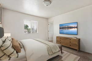 Bedroom with light colored carpet. Virtually staged primary suite.