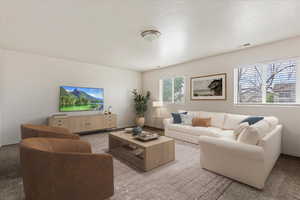 View of carpeted living room. Lower gathering room virtually staged.