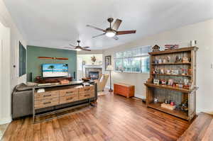 Living room with ceiling fan and wood-type flooring