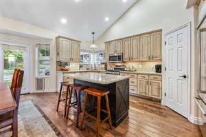 Kitchen featuring stainless steel appliances, pendant lighting, a center island, and tasteful backsplash. Large View window to private backyard