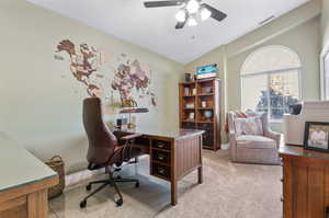 Carpeted office featuring ceiling fan and lofted ceiling