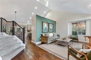 Living room featuring beam ceiling, high vaulted ceiling, and dark hardwood / wood-style flooring