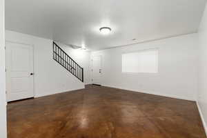 View living room  with white painted walls, stamped, dark brown concrete flooring