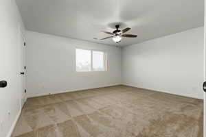 Carpeted primary bedroom featuring ceiling fan