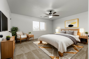 View of virtually staged primary bedroom with ceiling fan, white painted walls, and light carpet