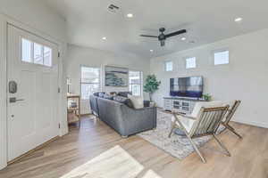 Living room featuring ceiling fan, a healthy amount of sunlight, and light wood-type flooring