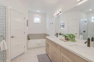 Bathroom featuring plus walk in shower, tile patterned floors, and vanity