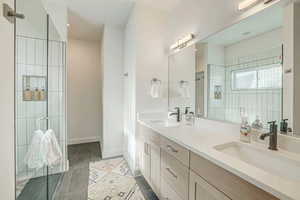 Bathroom featuring tile patterned floors, vanity, and a shower with shower door