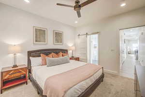 Bedroom with ceiling fan and a barn door