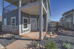 View of exterior entry with a balcony and a patio