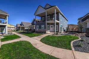 Rear view of house featuring a balcony and a lawn