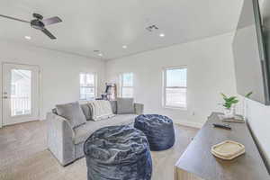 Living room featuring ceiling fan and light carpet