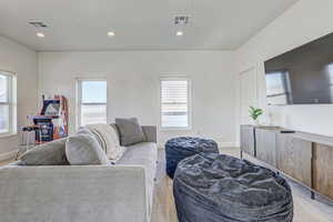 Living room featuring light colored carpet and a healthy amount of sunlight