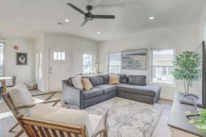 Living room with ceiling fan, light wood-type flooring, and a healthy amount of sunlight