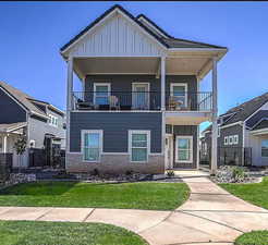 View of front of home with a front lawn and a balcony