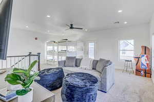 Carpeted living room with ceiling fan