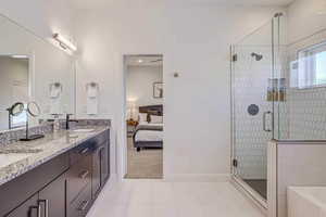 Bathroom featuring walk in shower, tile patterned flooring, and vanity