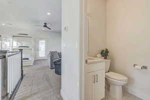 Bathroom with ceiling fan, tile patterned flooring, vanity, and toilet