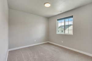 Spare room featuring a textured ceiling and carpet