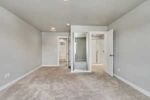 Unfurnished bedroom featuring light colored carpet