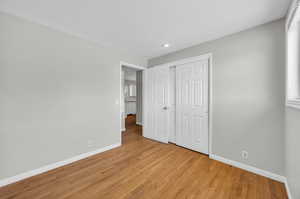 Unfurnished bedroom featuring light hardwood / wood-style floors and a closet