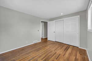 Unfurnished bedroom with hardwood / wood-style floors and a closet