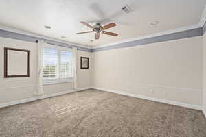 Spare room with carpet floors, ceiling fan, and crown molding