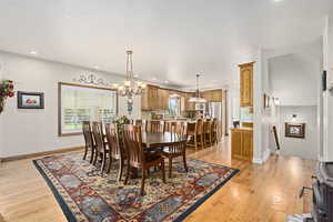 Dining area featuring light wood-type flooring and a notable chandelier