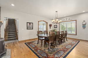 Dining area with light hardwood / wood-style floors and a chandelier