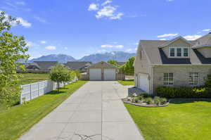 View of front of house with a garage, a front lawn, and a mountain view