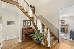 Stairway featuring hardwood / wood-style floors and a brick fireplace