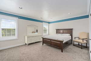 Carpeted bedroom with ornamental molding