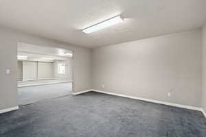 Spare room featuring a textured ceiling and carpet