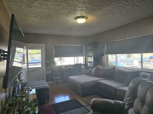 Living room with a wealth of natural light and hardwood / wood-style flooring