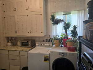 Laundry room featuring washer and dryer and cabinets