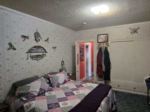 Bedroom featuring a textured ceiling and carpet