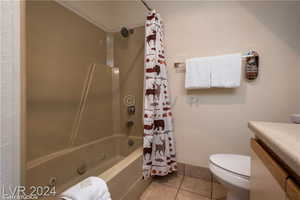 Full bathroom with toilet, vanity, shower / bath combo, and tile patterned floors